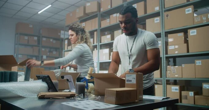 Multiethnic Delivery Service Workers Packing Cardboard Parcels with Online Goods, Food, Scanning Code with Scanner, Preparing Packages for Shipping to Clients. Retail Warehouse of E-Commerce Store.