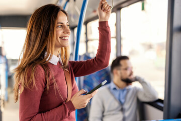 Young woman with cellphone in hands riding city bus and looking trough the window. © Dusan Petkovic