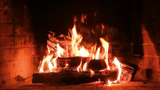 Fire burning in a fireplace, wood logs and flames. Warm home, heat. Christmas holiday