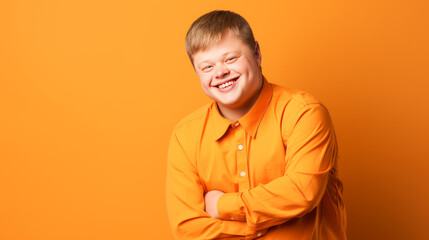 Portrait of smiling laughing man with Down syndrome orange background.
