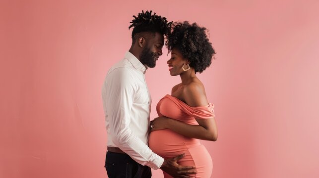 A romantic interaction occurs between a pregnant woman and a black man, showcasing their affection towards each other. The intimate setting with a solid pink background creates a warm atmosphere