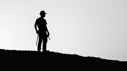 Obraz premium Silhouette of a Construction Worker on Hilltop