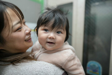 A Japanese mother in her 20s and a 6-month-old baby girl are in an elevator.