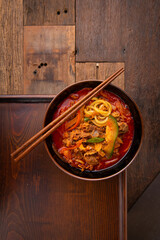 Spicy ramen, vegetables, and meat on the table