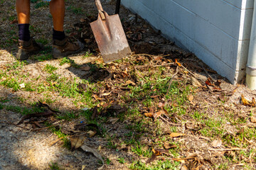 mans feet shovel ground leaves workman
