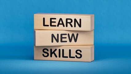 Obraz premium Learn new skills symbol. Concept words Learn new skills on wooden blocks.Business and Learn new skills concept. Copy space.3D rendering on blue background.