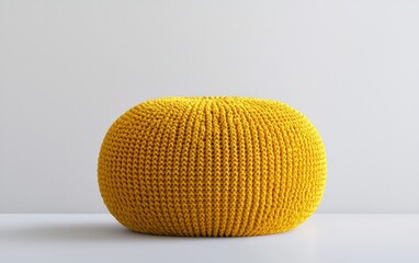 A vibrant yellow pouf with a knitted texture, perfectly centered on a clean white surface