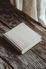Fototapeta premium Linen-Covered Pocket Notebook on Rustic Wooden Surface