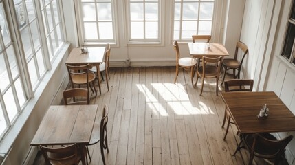Fototapeta premium Sunlit cafe interior with wooden tables and chairs.
