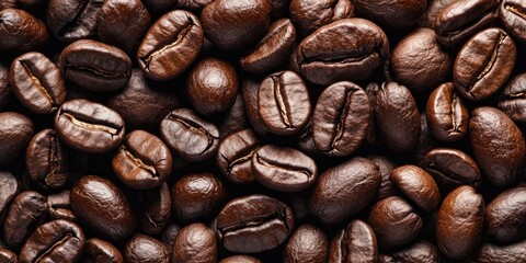 Obraz premium Detailed close-up of rich dark brown roasted coffee beans scattered uniformly across the frame, highlighting their glossy surfaces and textures.