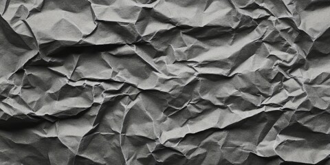 Crumpled gray paper texture background with intricate folds and shadows creating depth in a monochromatic layout for design use.