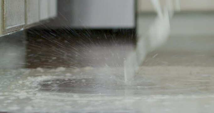 Milk being continually spilled onto kitchen floor in epic slow motion