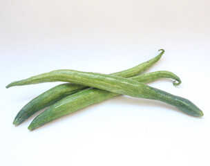 Trichosanthes anguina (Linn.) Common name is Snake gourd. Fruit is round and long with a pointed tip, smooth skin, with white and green stripes all over the fruit. Isolate on white background. 