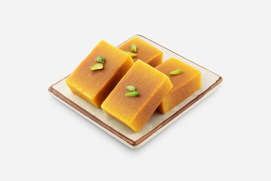 Mysore pak, a traditional, popular, and delicious sweet dish native to the city of Mysore, Karnataka, India, is made from ingredients like gram flour, ghee and sugar, on a ceramic plate.