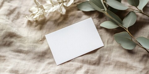 Minimalist 2x3 Card Mockup on Soft Linen Background with White Ruscus Branch and Eucalyptus Leaves in Natural Tones on Right Side