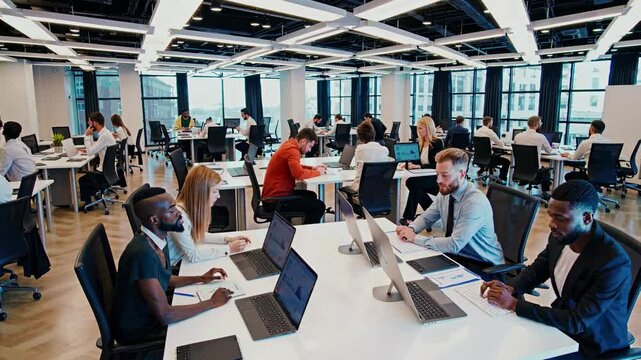 Busy modern office environment with employees collaborating and working at desks in a high-rise building - Powered by Adobe