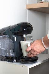 Close-up view of a woman's hand preparing a coffee in a coffee pot. Coffee and home concept