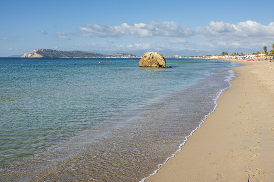 Poetto beach in Cagliari, with blue water and a characteristic rock in the sea