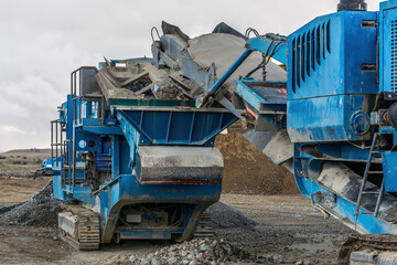 Fototapeta premium Heavy and mobile machinery in a quarry to transform stone into construction material