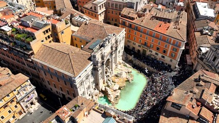 La fontana di Trevi a Roma, gremita di turisti, vista dall'alto.
Ripresa aerea con drone della Fontana di Trevi piena di visitatori in una giornata estiva.