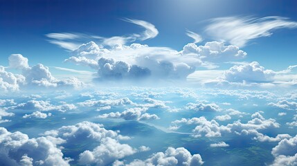 A breathtaking aerial view of a vast sky filled with fluffy white clouds and blue sky, some land can be seen at the bottom