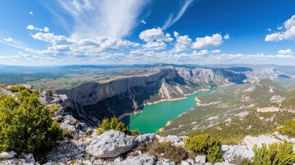 Obraz premium Scenic panoramic view of a turquoise lake surrounded by mountains.