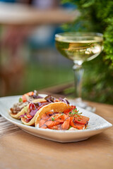 A vibrant and refreshing trio of tacos, each filled with slices of smoked salmon, fresh vegetables, and a drizzle of creamy sauce