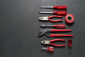 Tools organized neatly on a dark surface in a workshop setting for repair tasks