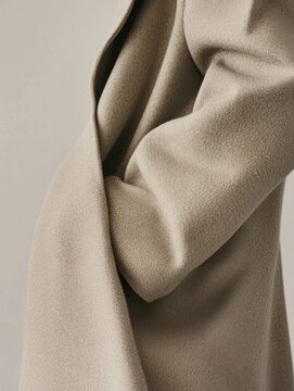 Minimalist beige coat with gentle folds and curves
