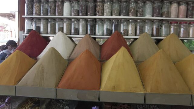 display of spices for cooking in the shape of a pyramid in a shop inside the souq of Marrakech, spices and flavors typical of Moroccan tjine cuisine, curry, cumin and paprika