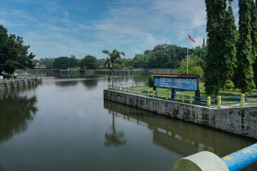 Fototapeta premium Scenic View of Tambakboyo Reservoir Surrounded by Trees and Clear Sky
