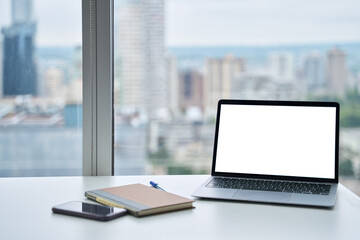 Open laptop mock up screen on work table, modern computer technology device in skyscraper luxury...