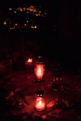A Bunch Of Grave Candles Glowing With A Red Light On A Gravestone On All Saints' Day In The Night, Blurry Grave Candles Glowing In The Background