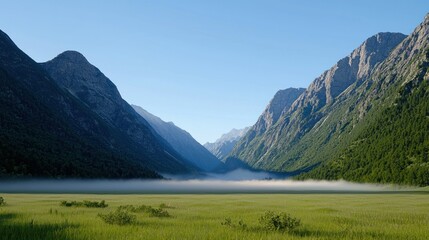 Serene valley landscape with mountains and fog in the foreground.