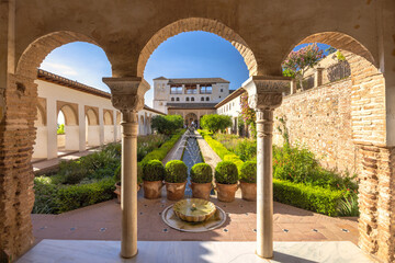 The Patio de la Acequia, courtyard of the Generalife palace at the Alhambra complex in Granada town, Andalusia, Spain. Serene courtyard garden with fountain and classical architecture.