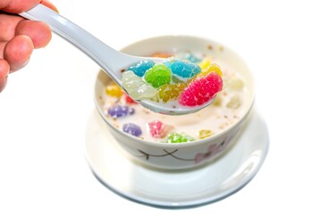 Photo of Thailand dessert with kind of thai sweetmeat served with coconut slices and banana slices topped put on banana leaf with concept isolated