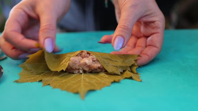 People cook dolma food.
Grape leaves stuffed with minced meat.