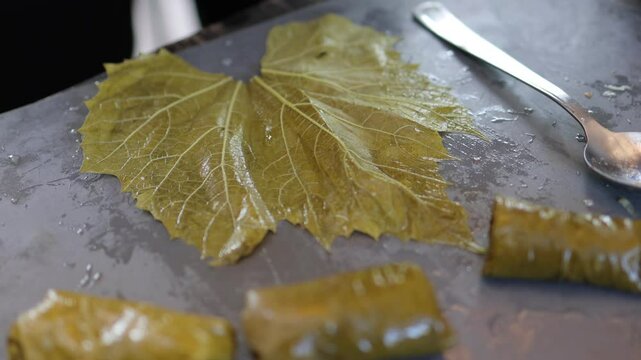 People cook dolma food.
Grape leaves stuffed with minced meat.