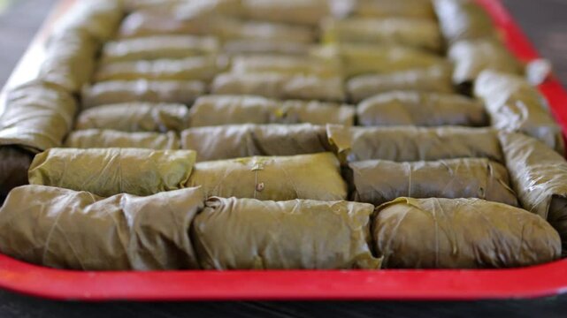 People cook dolma food.
Grape leaves stuffed with minced meat.