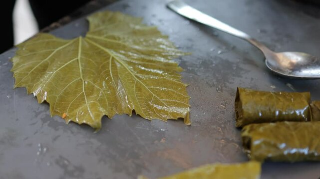 People cook dolma food.
Grape leaves stuffed with minced meat.