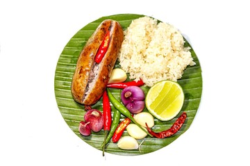 Top view, look delicious with food Thailand with menu fried sausage with sticky rice served on banana leaves with chili onions and lemon slices put on white background in isolated concept.