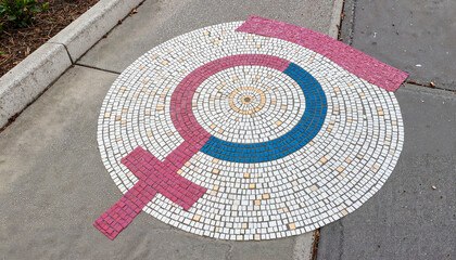 Mosaic female symbol on sidewalk in urban setting, community representation