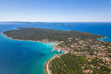 Fototapeta premium Aerial drone view of Croatian island Silba with beautiful beaches. Amazing Adriatic sea tourist vacation destination in Croatia. Panoramic paradise blue sea, sandy beaches, old houses and boats