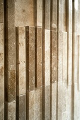 Fototapeta premium Light brown textured stone panels in vertical pattern.