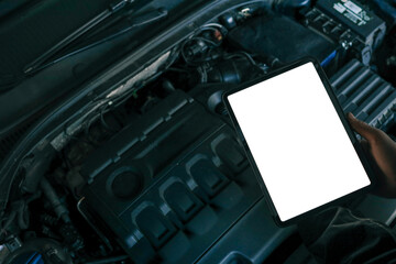 A tablet with a blank screen held by a mechanic above a car engine, symbolizing modern diagnostic...