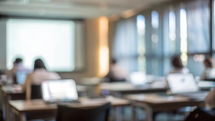 Workshop Training Space Blur: A bright training room with blurred desks, laptops, and participants focusing on a presentation.
