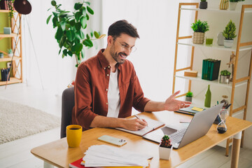 Smiling man working at home desk in a modern apartment for productive remote communication