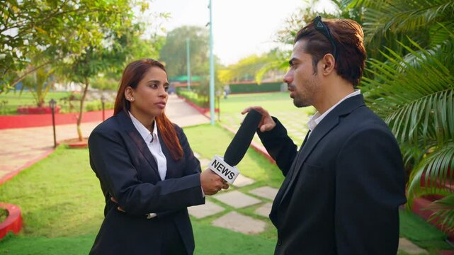 Girl reporter interviews a boy standing in garden setting