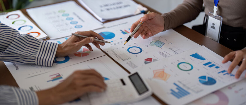 Business team collaborating on financial analysis with charts and graphs during a strategy meeting - Powered by Adobe