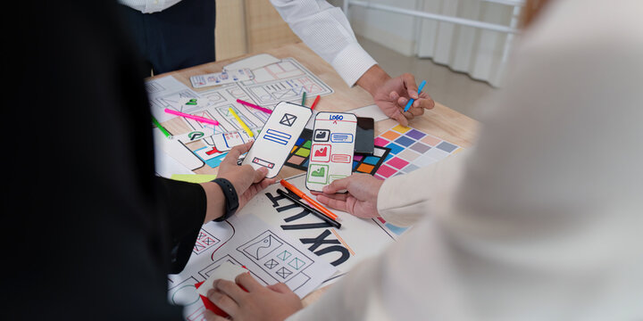 Dynamic UX UI team reviewing mobile app wireframes and sketches during a collaborative design session
